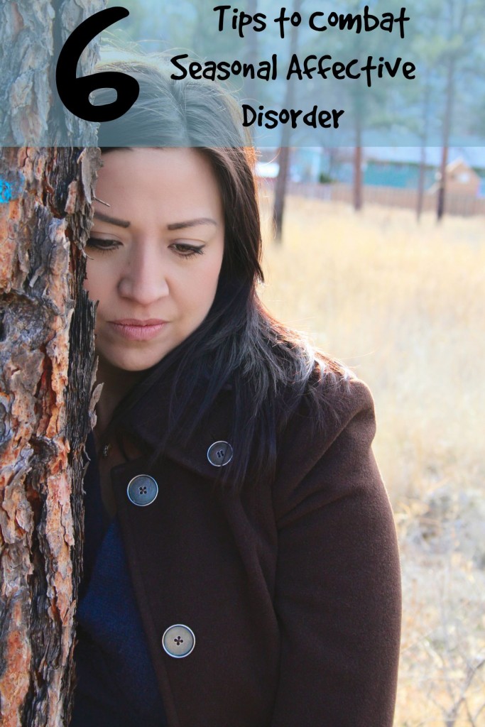 Beautiful brunette female leaning against a tree looking out